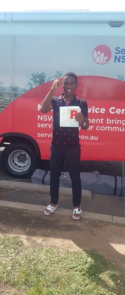 Smiling Road to Licence student celebrating his driving test pass with a P plate