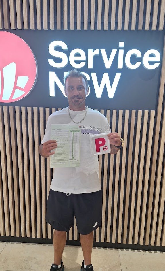 Road to Licence student showing his P plate and passed driving test sheet at Service NSW