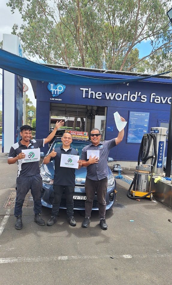 Three Road to Licence students celebrating with their certificates in front of the driving school car